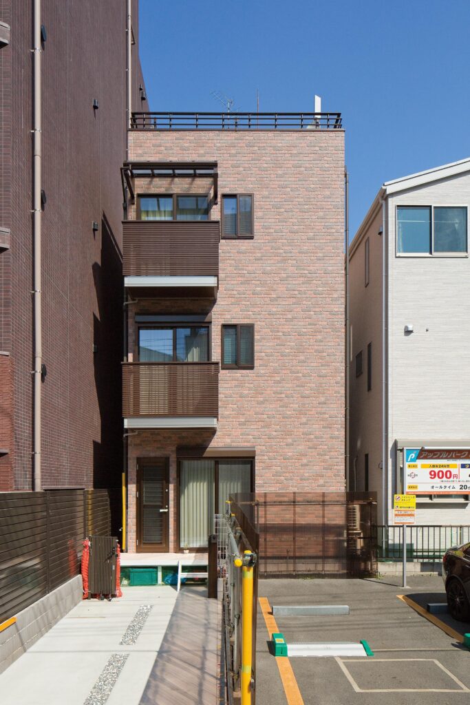 玄関は建物反対側の北側にあるが、日当たりのいい南側にリビングへの入口を設け、駐車場からも出入りできるようにしている。奥様の趣味を反映して、外壁にはレンガ調のサイディングを採用した。