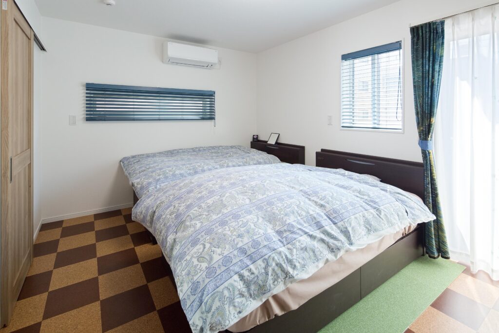 寝室の床はコルク調のタイルを市松模様にデザイン。ワイン好きのご夫妻の趣味を反映した。