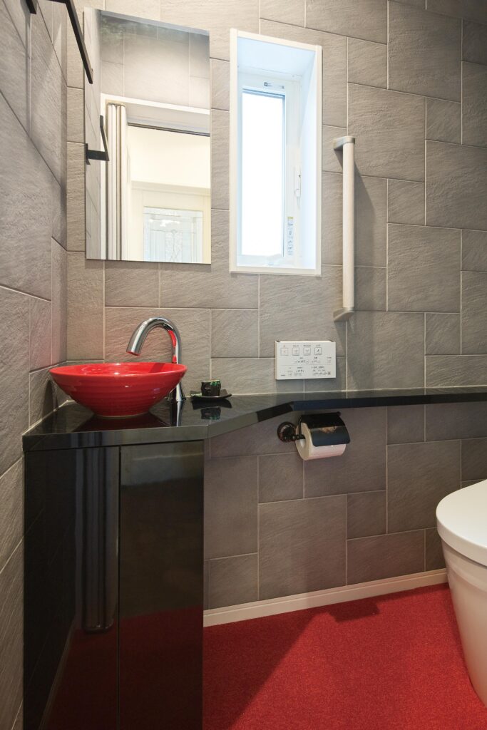 赤い洗面ボウルを入れたこだわりのトイレ。