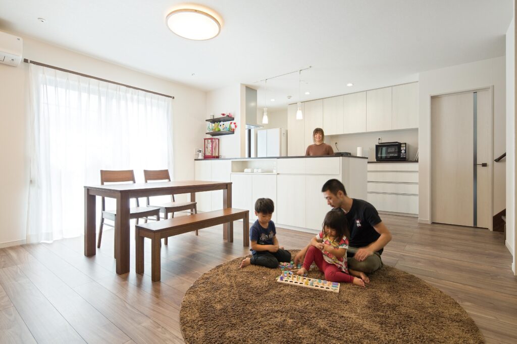 明るい日差しが差し込み、心地よく暮らせるLDK。床は標準仕様のウォルナット系のフローリングで、ナチュラルな雰囲気を演出。キッチン右横に階段を設けることで、“家族が出会う場”を実現している。