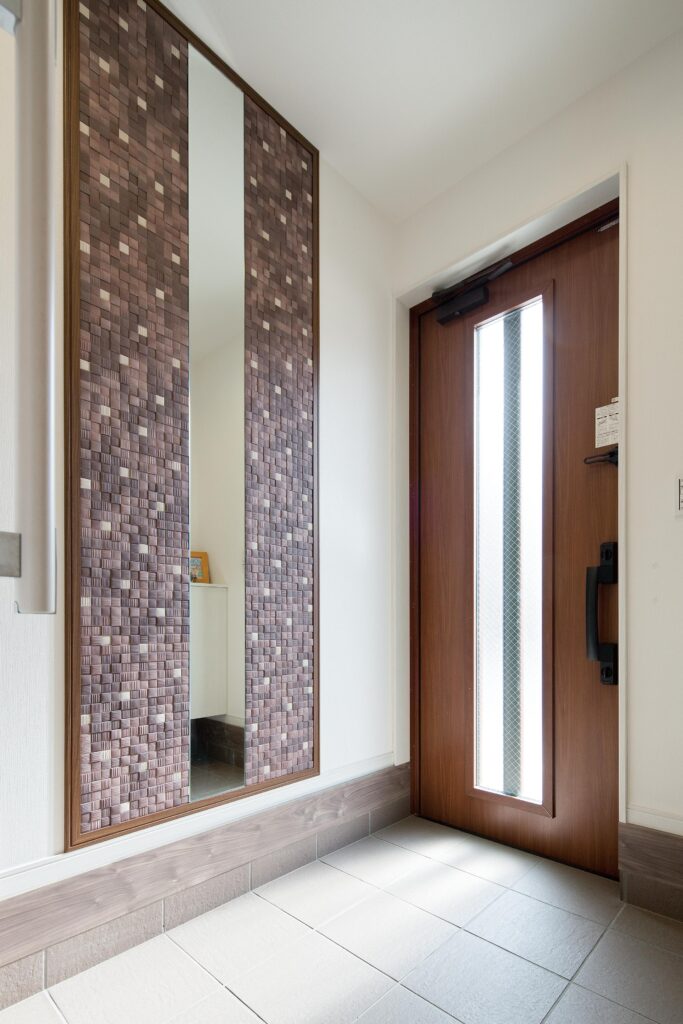 ミラーの周りにエコカラットを 貼った玄関ホール。デザイン性 はもちろん、調湿・消臭作用も